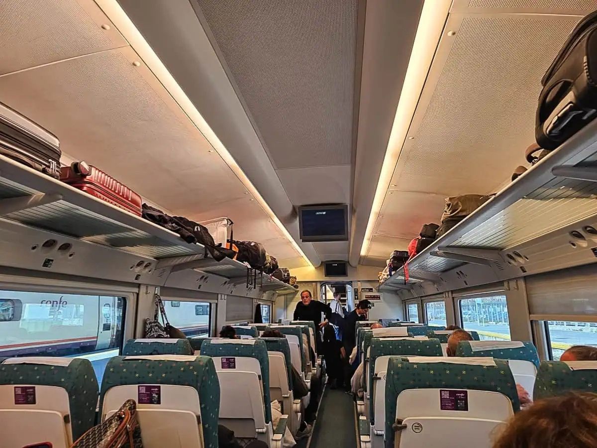 Интериор на вагон Renfe между Гранада и Кордоба, Испания с пътници и багаж по рафтовете